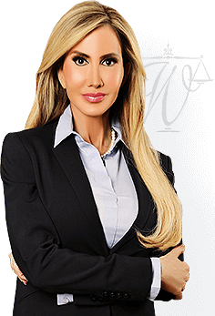 A woman with long blond hair in a black blazer and white shirt poses with arms crossed, with a logo of scales in the background, embodying the professionalism of a Chicago divorce lawyer.